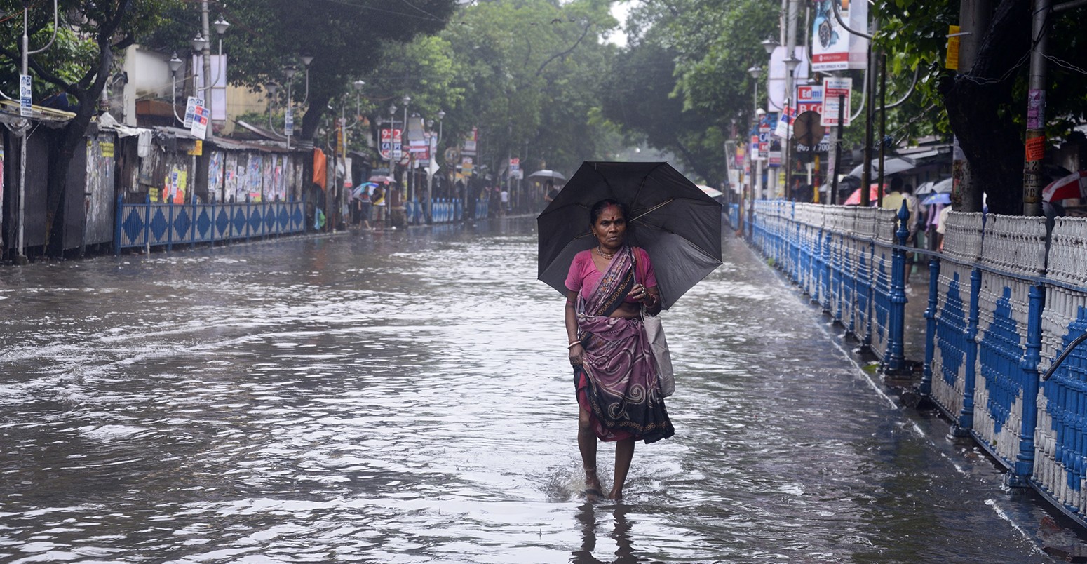Indian woman walks in a flooded street of Calcutta, India.