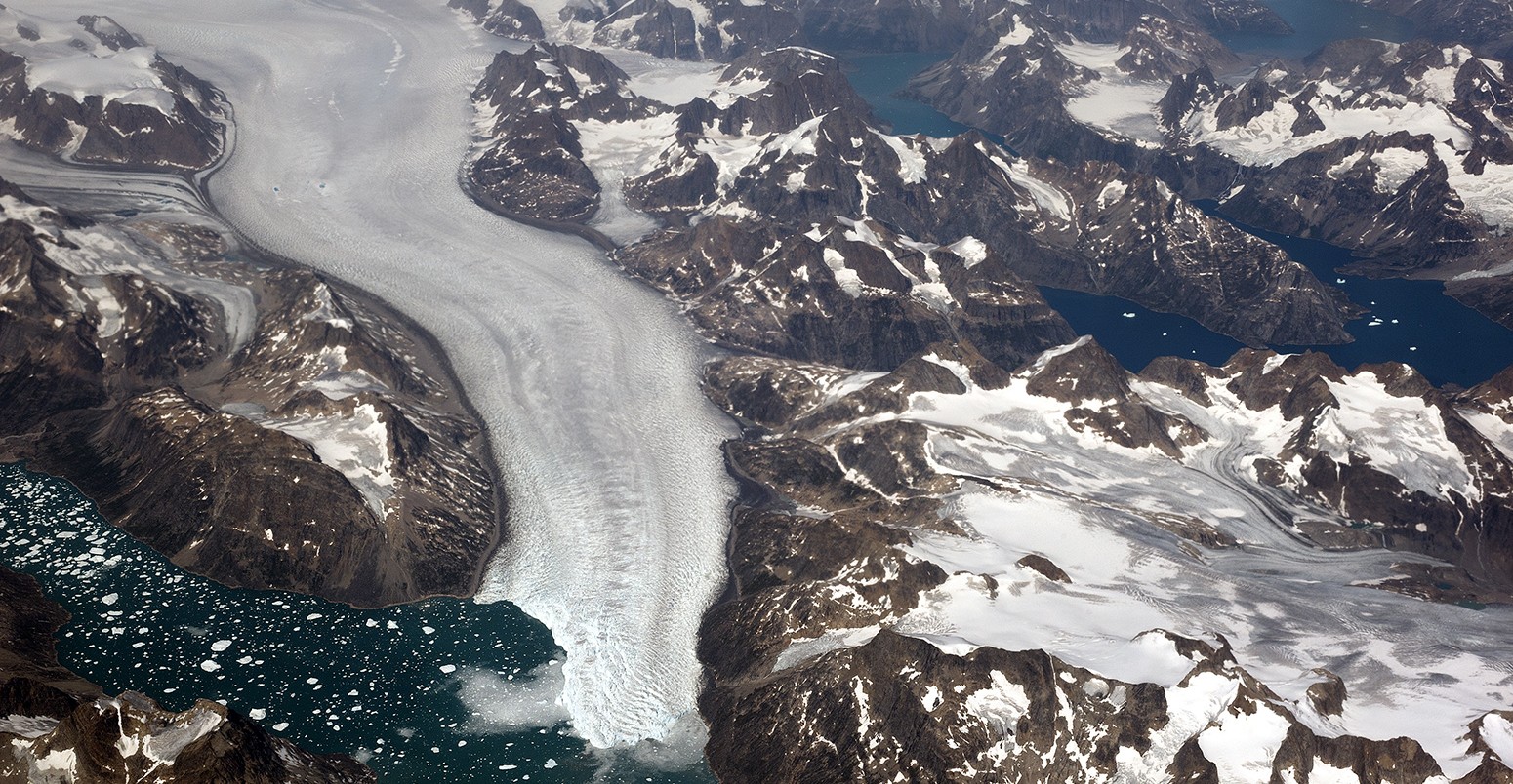 Aerial view of glacier and snow covered mountains in Greenland