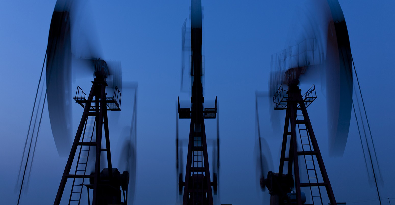 Working oil pumps in silhouette at night.