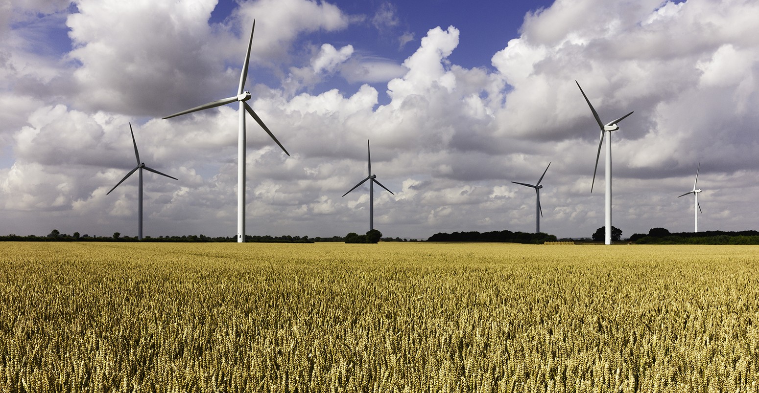 Wind farm in a wheat field and a storm brewing, near Lisset, Yorkshire, UK