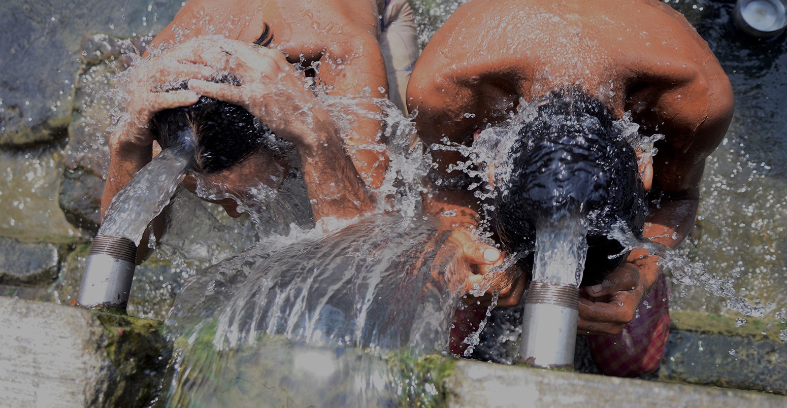 Local people take bath from municipal water source to keep them self cool from heat wave on June 10, 2015 in Calcutta, India.