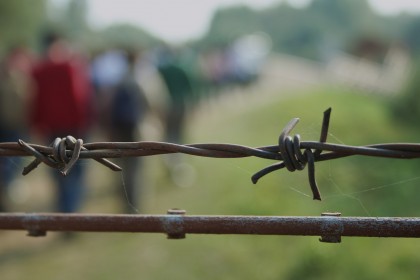 Migrants walking away from barbed wire in Syria