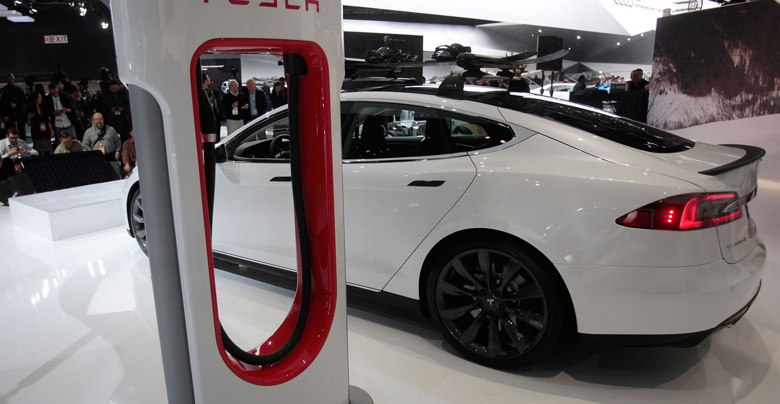 A Tesla S electric car and a charging station are displayed during the press preview day of the North American International Auto Show in Detroit