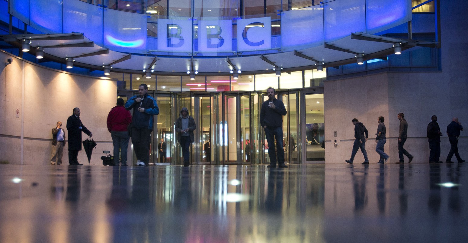 People arrive at, and leave, the BBC headquarters at New Broadcasting House in central London