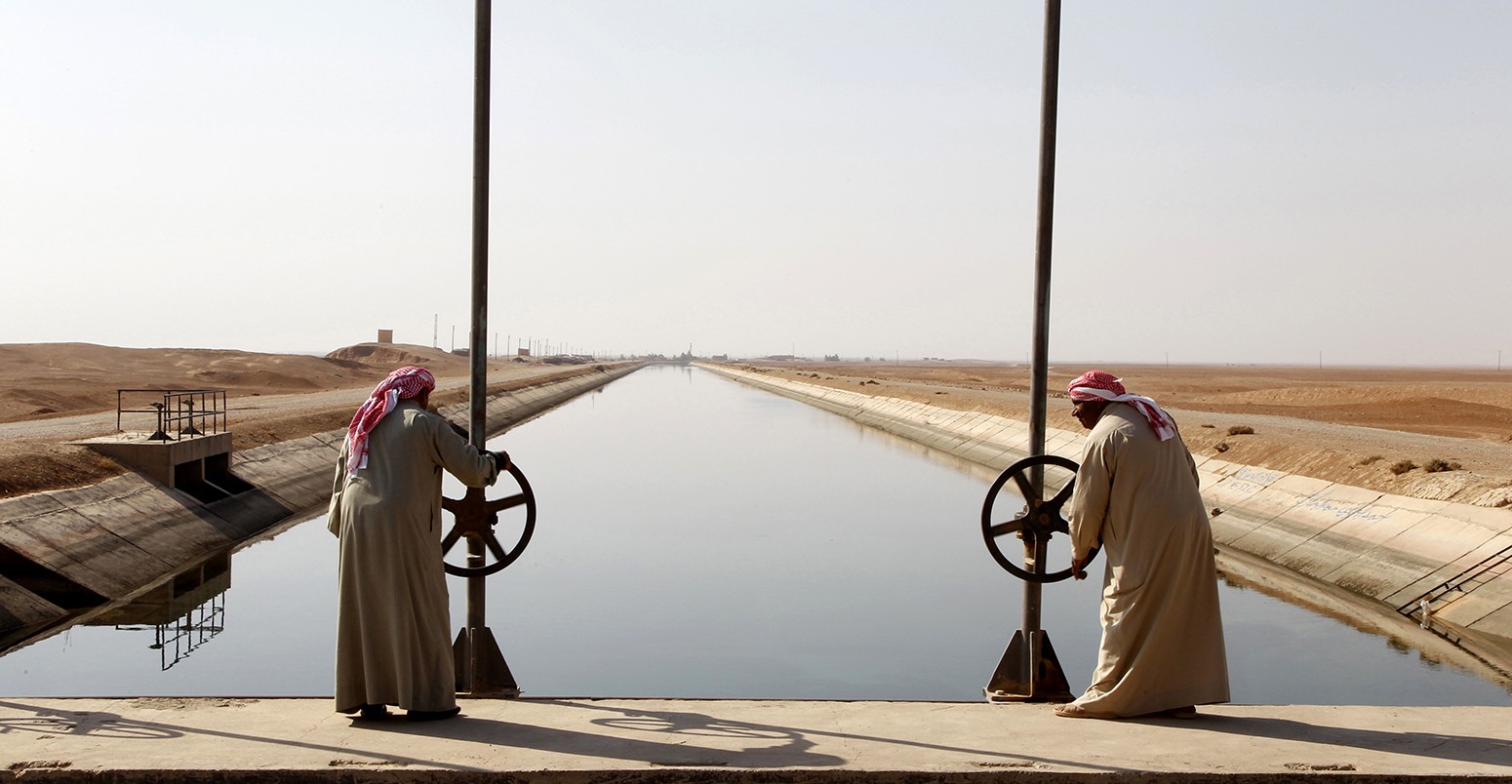 A view of a water canal running from the Euphrates river into the semi-desert region of eastern Syria