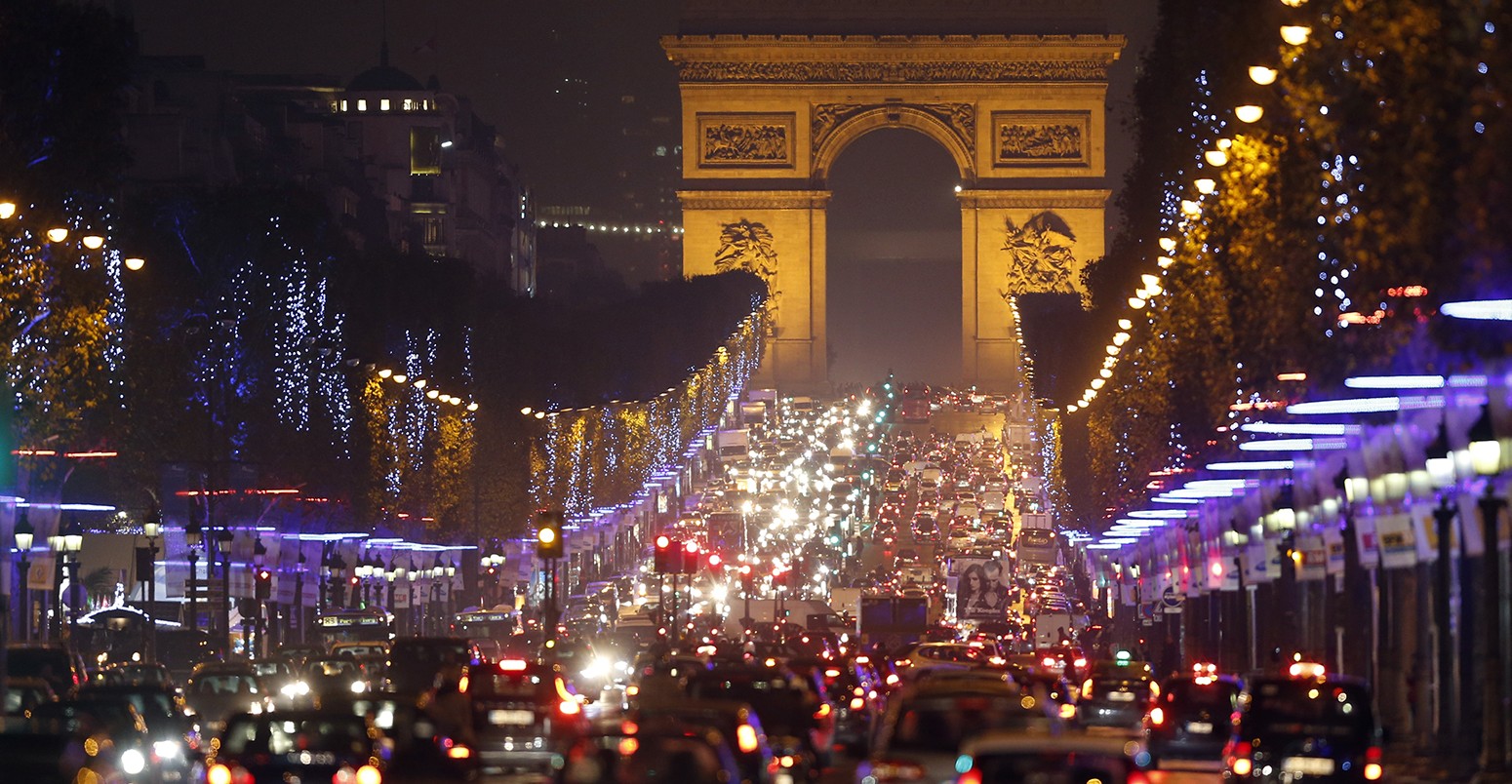 Christmas holiday lights decorate trees along the Champs Elysees with its Arc de Triomphe, in Paris November 21, 2013.