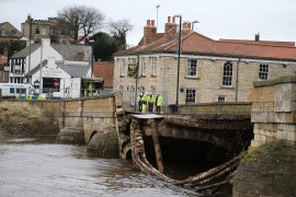 Members of the emergency service and police stand on the partially collapsed bridge in Tadcster, Yorkshire, northern England 30 December 2015 after heavy flooding caused the River Wharfe to break its banks. Residents have been evacuated from the village as Storm Frank hits many parts of the country. © EPA/NIGEL RODDIS