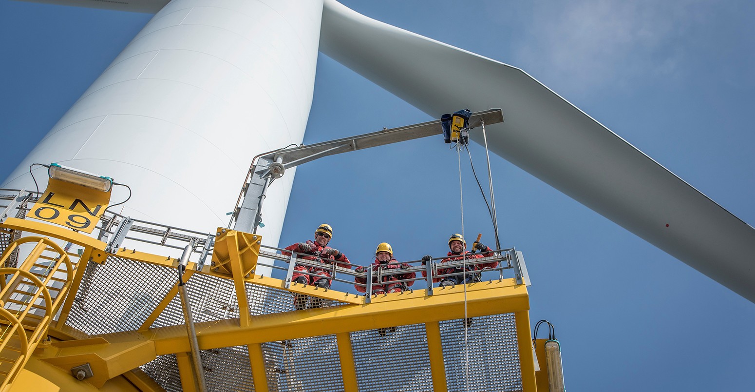 Portrait of engineers on wind turbine at offshore windfarm