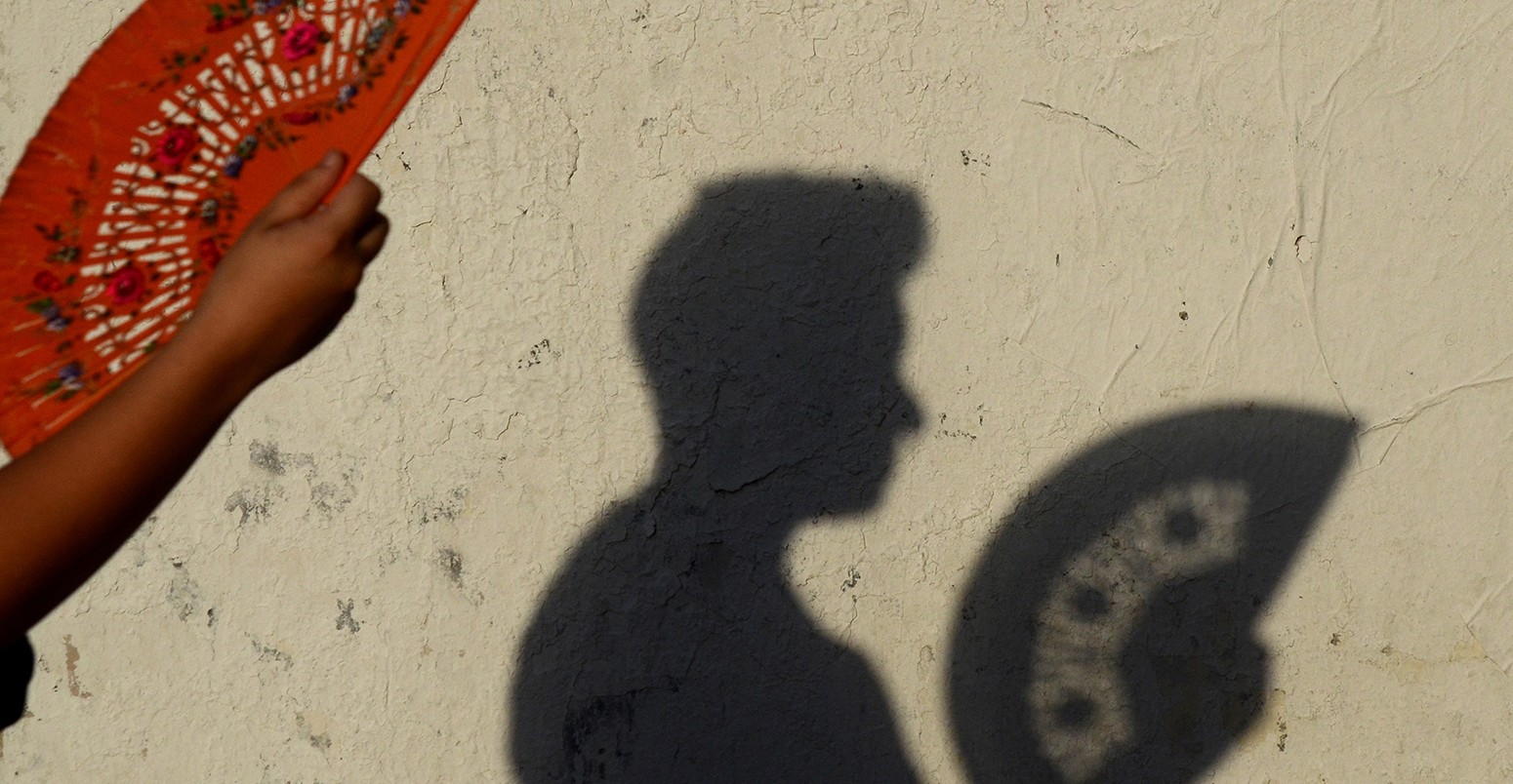 A woman uses a fan to keep cool as a heatwave continues in Madrid.