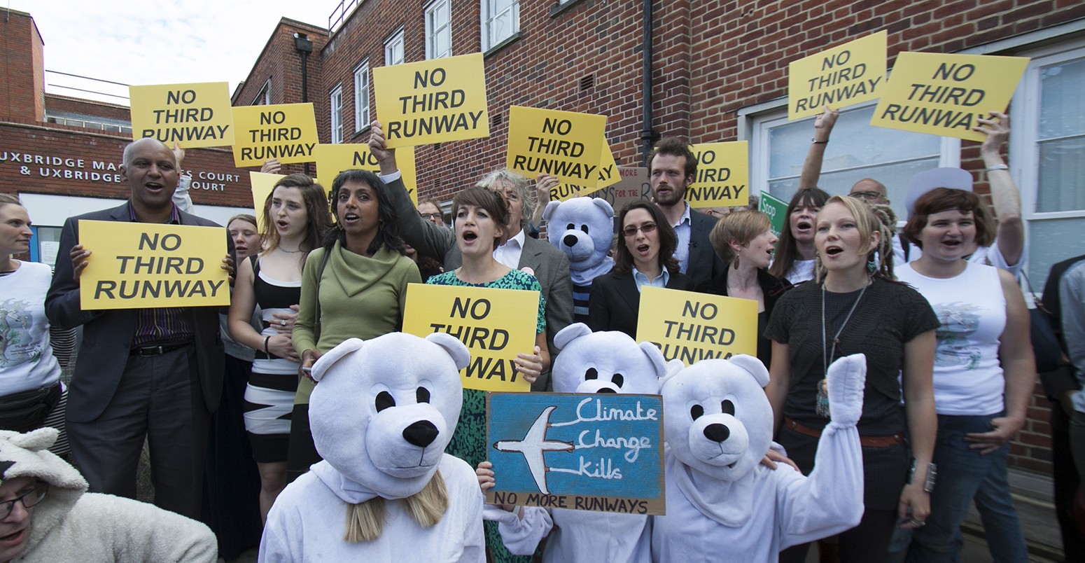 Plane Stupid activists and supporters wave placards in opposition to a third runway at Heathrow airport outside Uxbridge Magistrates courting West London. -- Plane Stupid climate change activists who oppose a third runway at Heathrow airport appear with their supporters dressed in Bunny rabbits at Uxbridge magistrates court.