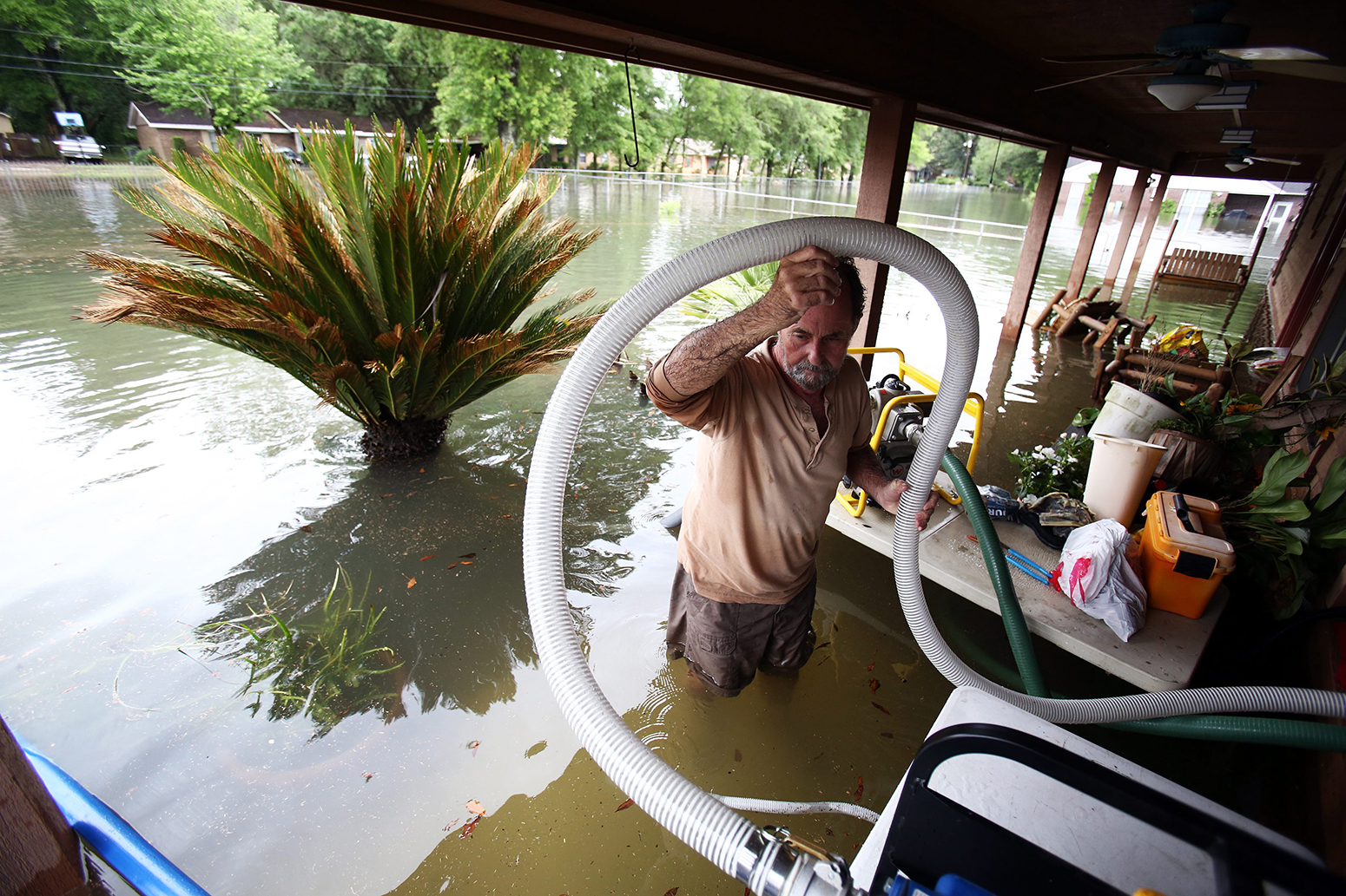 Kevin Davis tries to pump water out of his flooded home in Pensacola, Florida, USA, 30 April 2014.