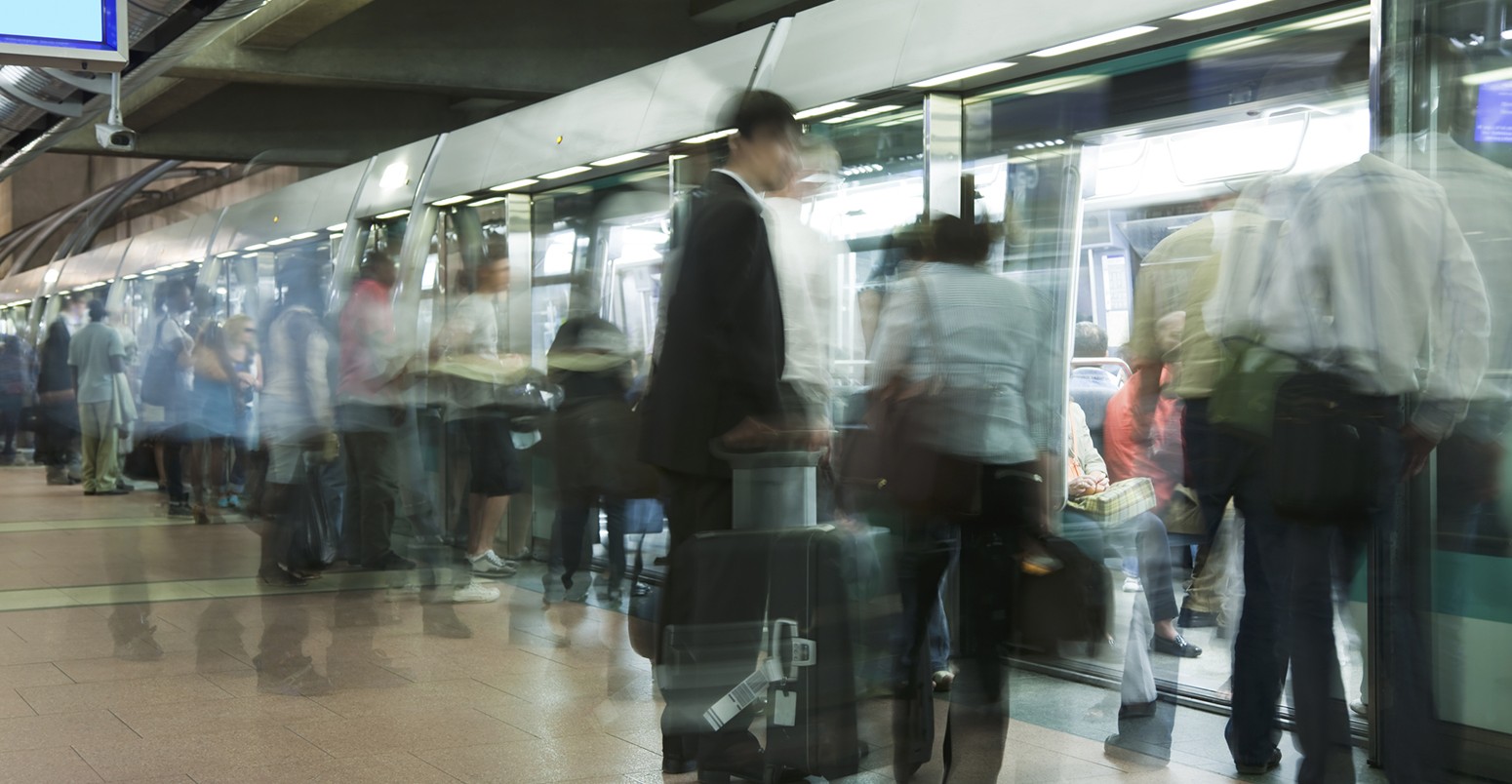 Blurred passengers waiting in underground station, long exposure.