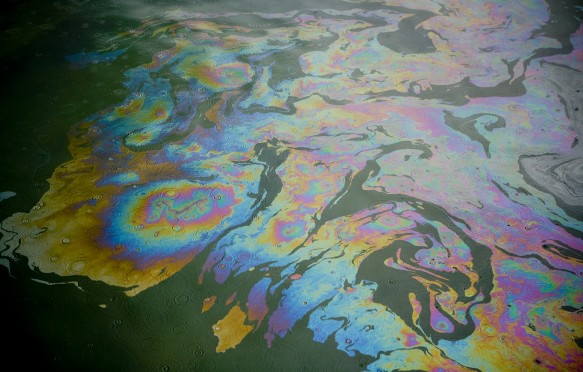 Diesel oil spill on the water surface during a light rain storm.