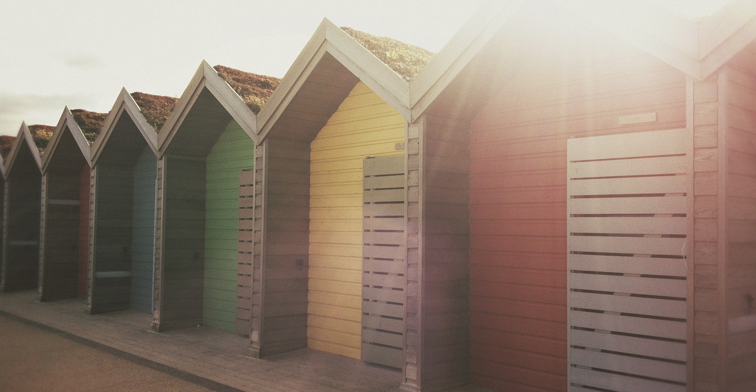 A row of colourful beach huts.