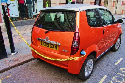 Orange electric car on charge, London, England, UK