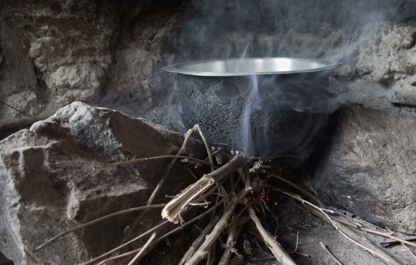 James Okeyo cooks dinner on his three stone cook stove in Kisumu, Kenya. The EnDev Kenya Country Programme is helping to replace these three older charcoal stoves with cleaner, less smoky wood burning stoves. Up to December 2015, 87,000 households have switched to the improved, cleaner burning jiko kisasa (firewood stove).