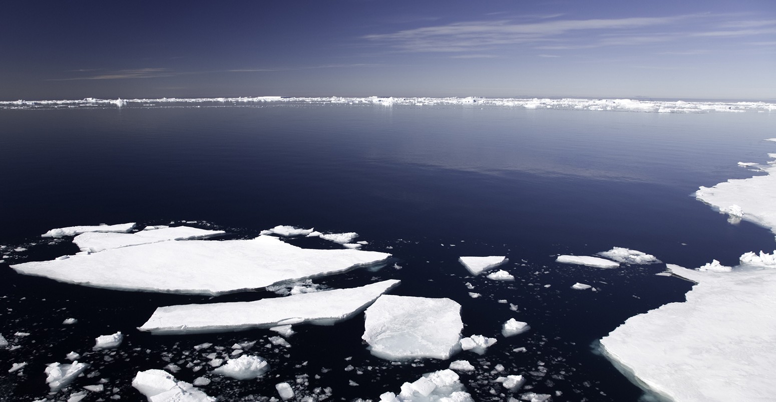 sheets of ice in antarctica, icebergs in the background, deep blue sunny sky