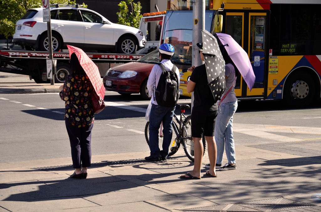 DN62FD Adelaide, South Australia 19th December 2013. Commuters in King William Street, Adelaide shelter from the heat in the grip of a 43c heat wave, with the city suffering its hottest December day since 1931. Credit: CandyAppleRed Images/Alamy Live News
