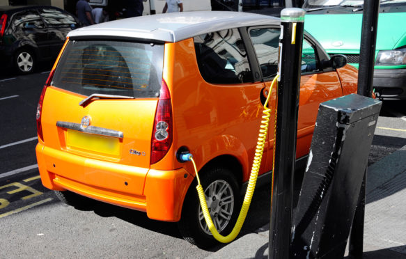 Electric car charging station cable hooked up to recharging bollard London UK
