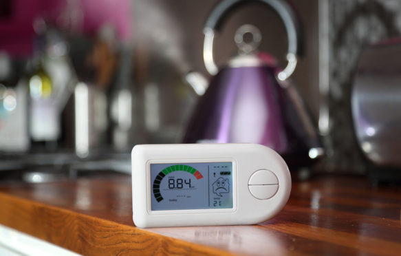 A domestic smart meter sat in front of a kettle.