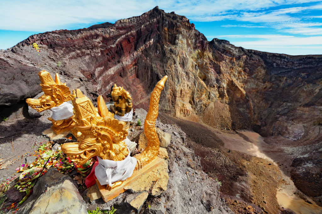 K9KTM1 Balinese shrine on brink of volcanic crater with traditional offering for spirits protecting against eruption. Summit of active volcano Agung Mount.