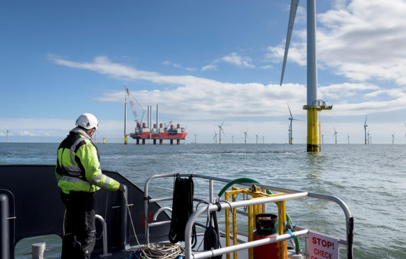 F1HEX0 Worker looking out from ship to offshore wind farm and construction ship.