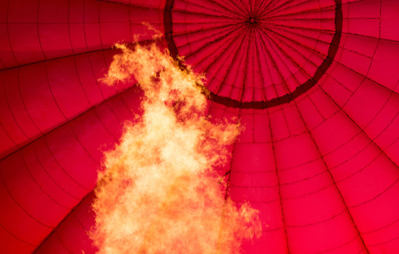 F66Y77 Gas flame heating hot air balloon to help it rise.