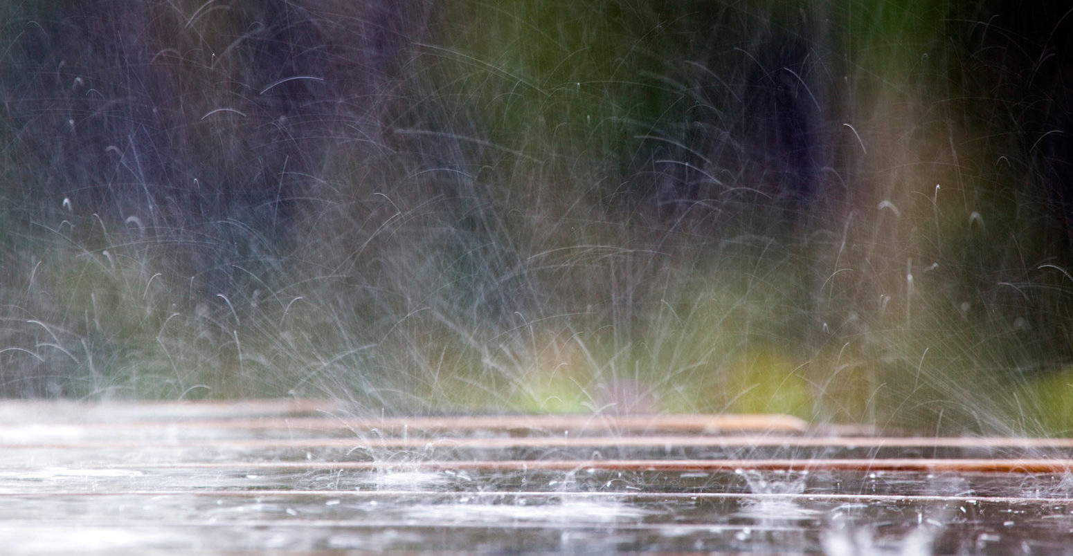 C5T9H7 Raindrops hitting a picnic table; Cornwall;UK.