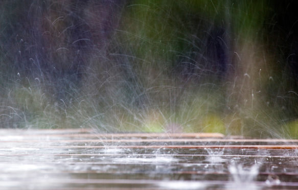 C5T9H7 Raindrops hitting a picnic table; Cornwall;UK.