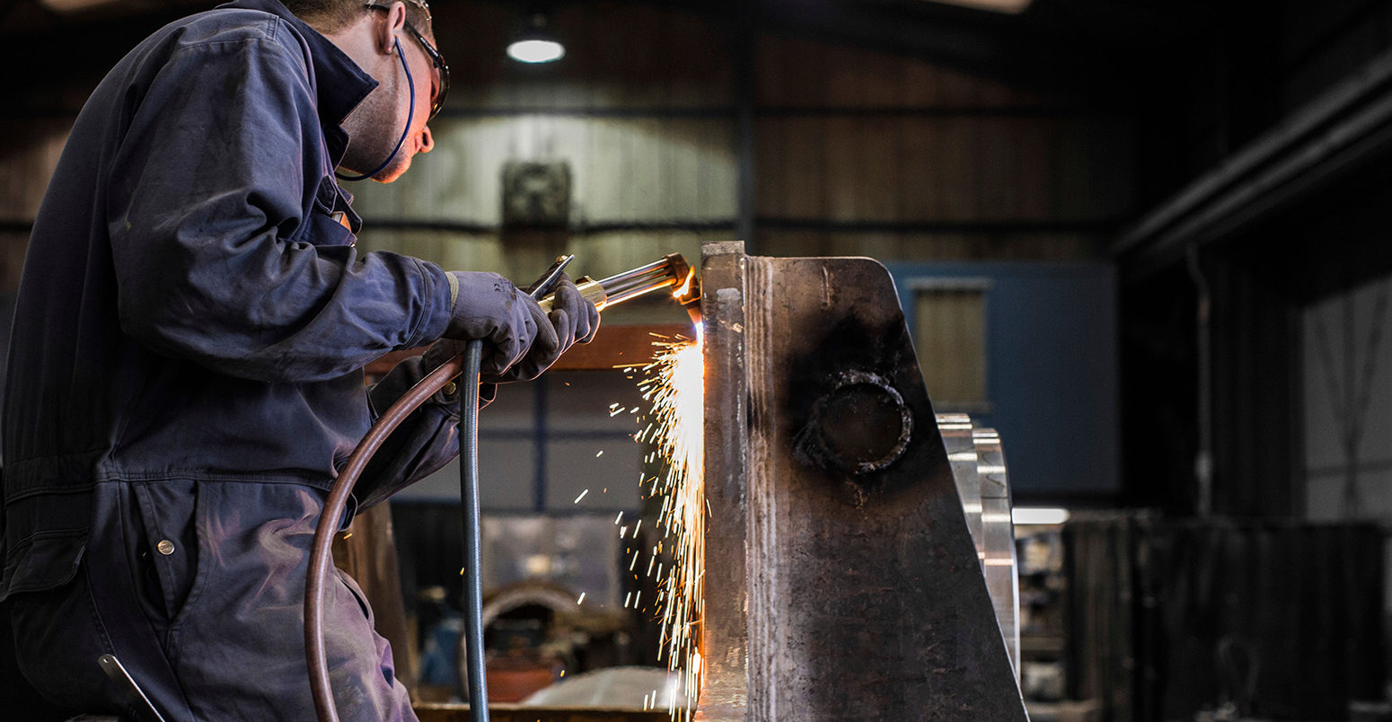 Steel Worker welds component for Oil and Shipping industry in UK Factory, near Aberdeen Scotland. Credit: Scott-Ray Johnson / Alamy Stock Photo DDRN2F