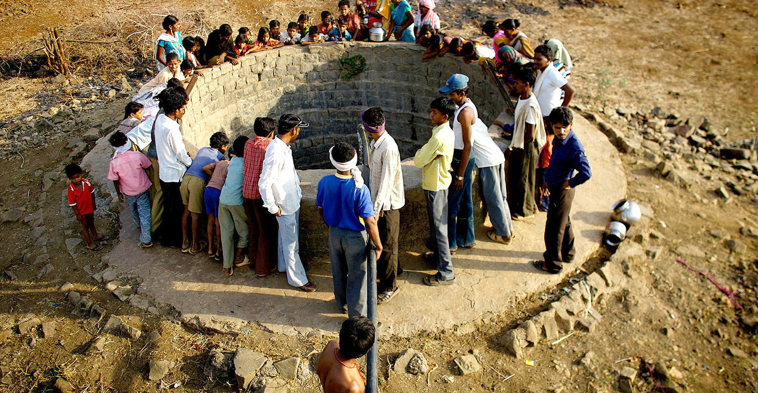 Mangi villagers wait for a water tanker that arrives twice a week to replenish their dried up water well. Pandharkawda, Maharashtra, India, 22 April 2010. Credit: ZUMA Press, Inc. / Alamy Stock Photo. CCX33P