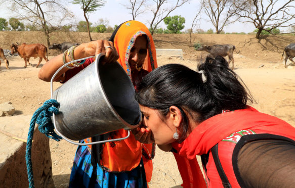 A woman quenches her thirst in Jaipur, India, during a severe heatwave in May 2016. Credit: PACIFIC PRESS / Alamy Stock Photo. G1TTR7