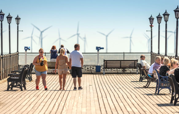 People enjoying the hot weather on Skegness Pier, UK, with offshore windfarms in distance. 2 July 2018. Credit: Steven Booth/Alamy Live News. P6R55H