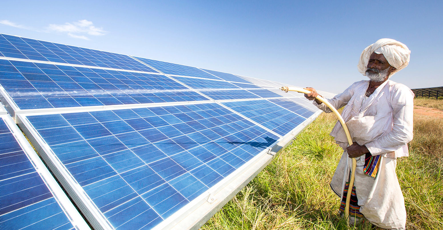 Cleaning solar panels in Gujarat Solar Park, Gujarat, India. Credit: Ashley Cooper pics / Alamy Stock Photo. DRARW5