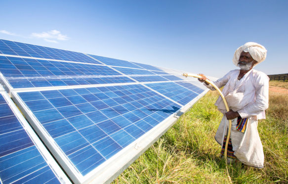 Cleaning solar panels in Gujarat Solar Park, Gujarat, India. Credit: Ashley Cooper pics / Alamy Stock Photo. DRARW5