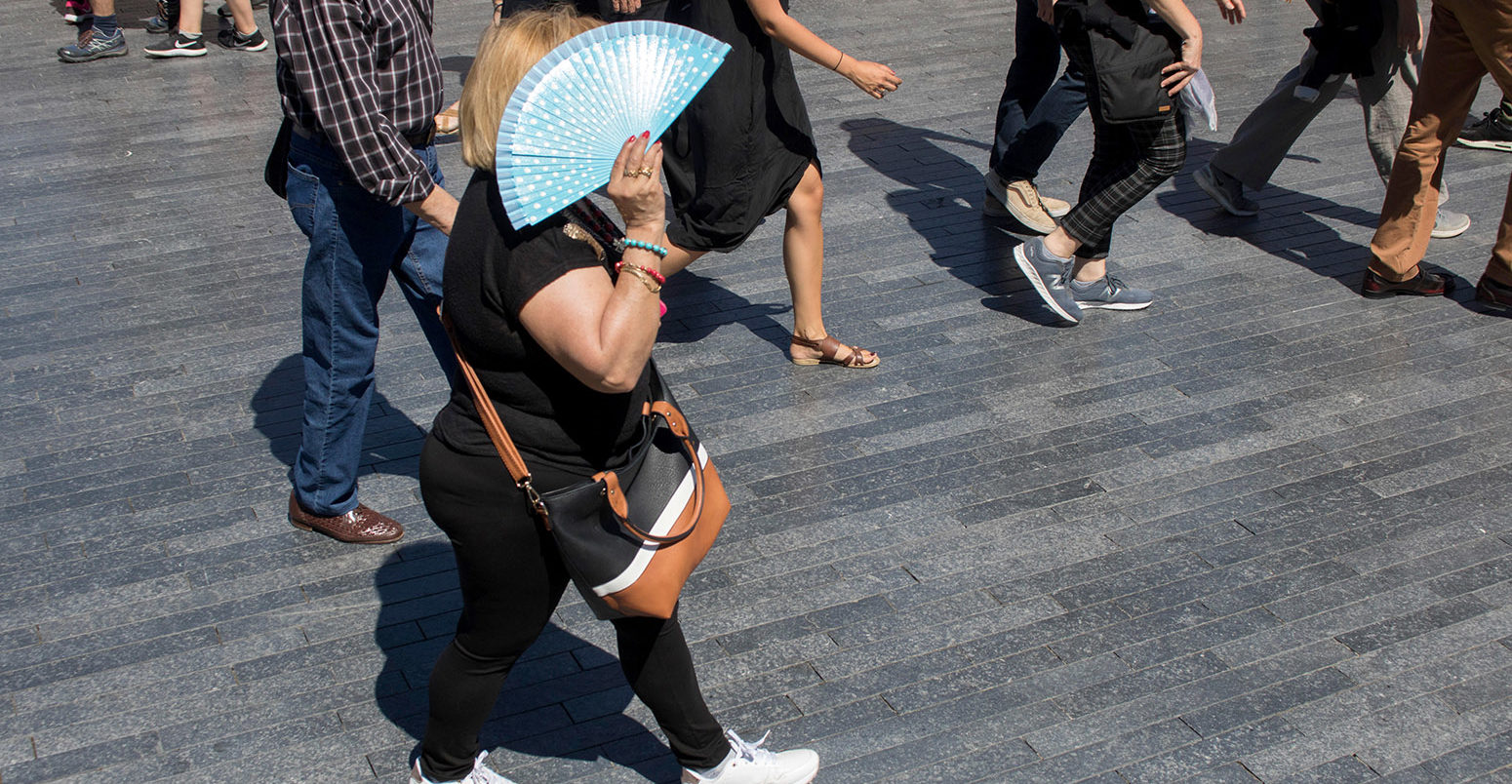 A woman shelters from the sun in London, during hot weather in August 2018. Credit: amer ghazzal / Alamy Stock Photo. PCFWGY