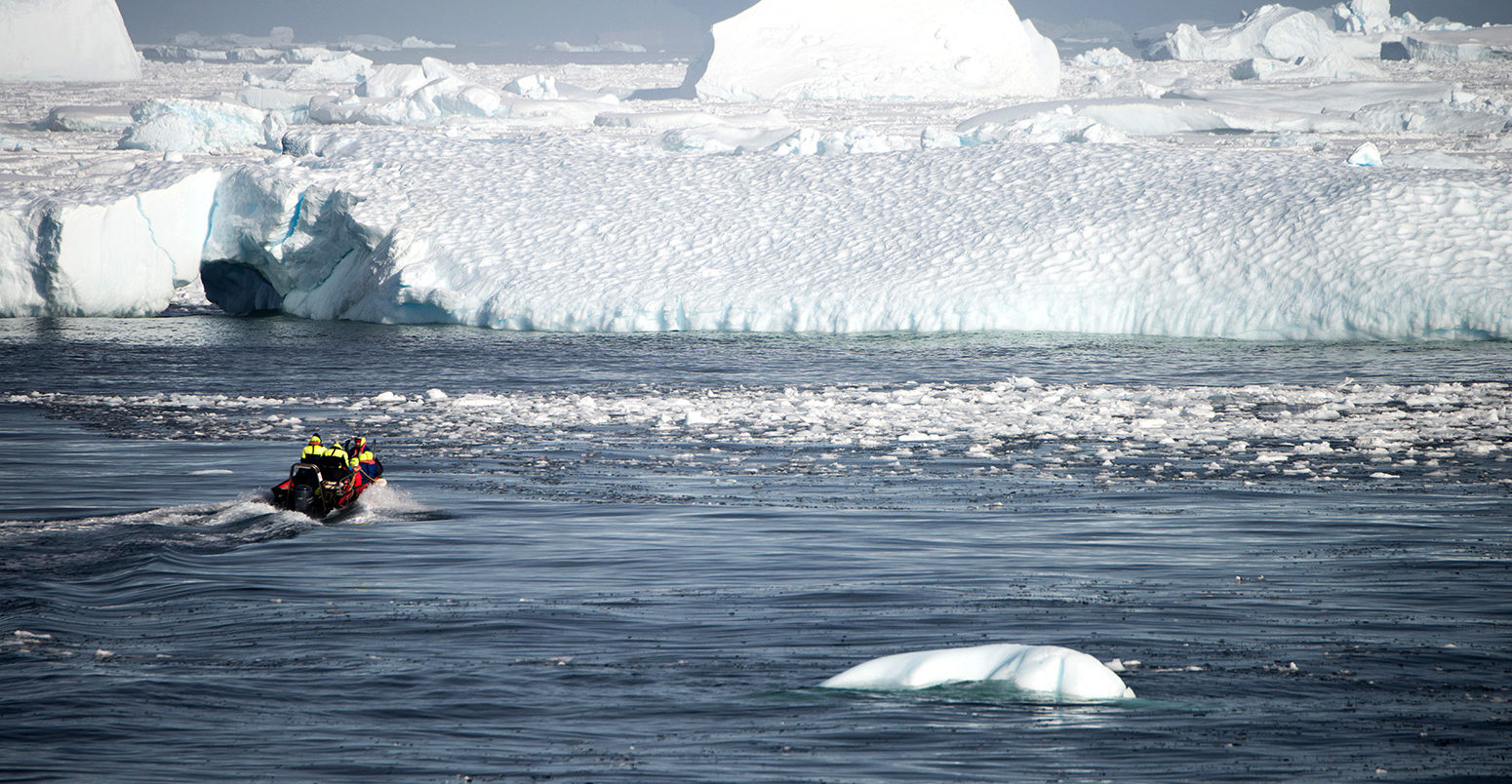 A boat transports people towards a glacier in Antarctica. Credit: Robert German / Alamy Stock Photo. M9B4XN