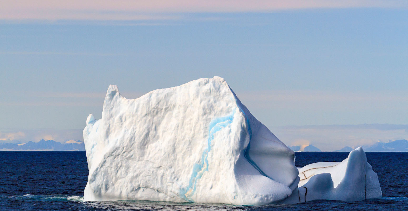 Iceberg floating in ocean water of Smith Sound in the high arctic of Nunavut, Canada, mid summer.