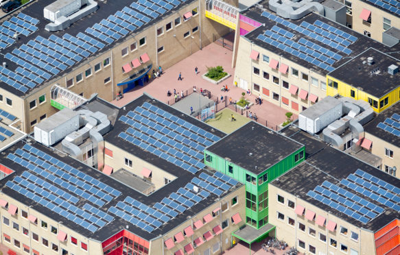 Solar panels cover the roof of a school, Zwolle, Netherlands. Credit: frans lemmens / Alamy Stock Photo. DHW93T