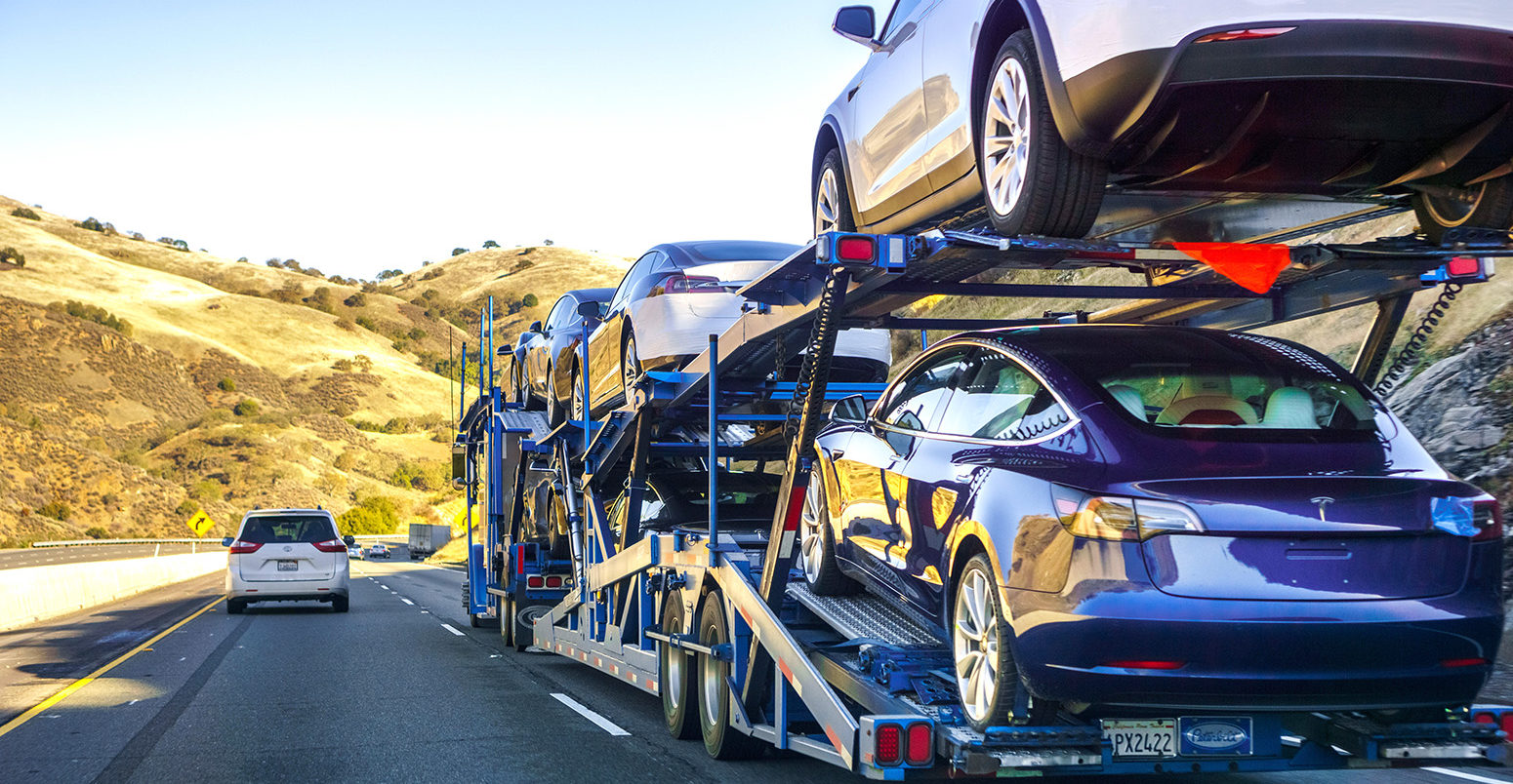 A car transporter carries new Tesla Model 3 vehicles along the highway, California, US. Credit: Andrei Stanescu / Alamy Stock Photo. R6HR26