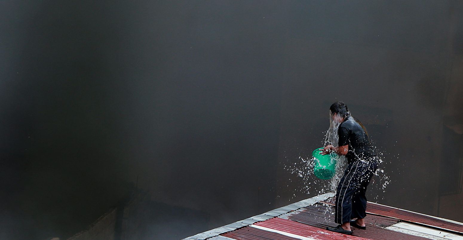 A man throws a bucket of water on himself to ease the extreme heat, Quezon City, Philippines. 5 March, 2019. Credit: Xinhua / Alamy Stock Photo.