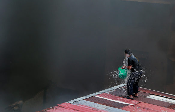 A man throws a bucket of water on himself to ease the extreme heat, Quezon City, Philippines. 5 March, 2019. Credit: Xinhua / Alamy Stock Photo.