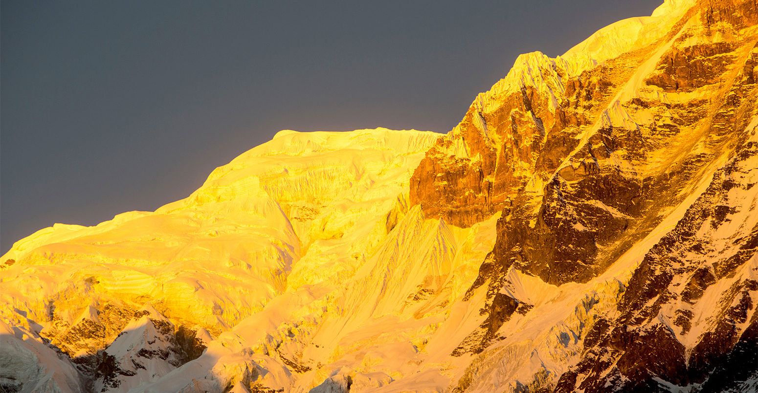 Alpenglow at sunrise on Annapurna South, Nepal Himalayas. Credit: Ashley Cooper / Alamy Stock Photo.