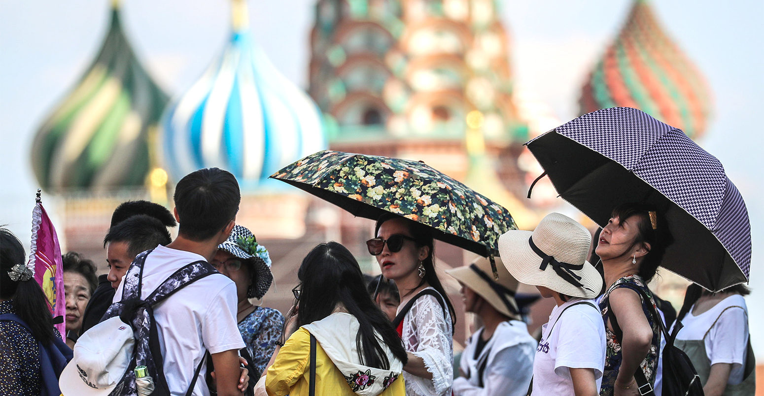 People take shelter under umbrellas during a heatwave in Moscow, 3 August 2018. Credit: ITAR-TASS News Agency / Alamy Stock Photo.