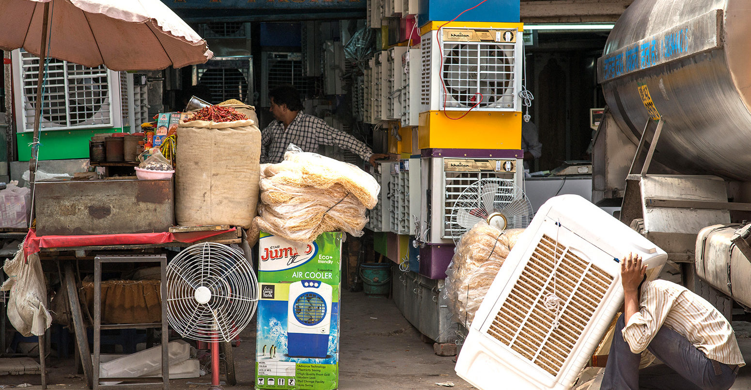 An air conditioning vendor prepares a unit for sale in Delhi, India. Credit: Kevin Su / Alamy Stock Photo.