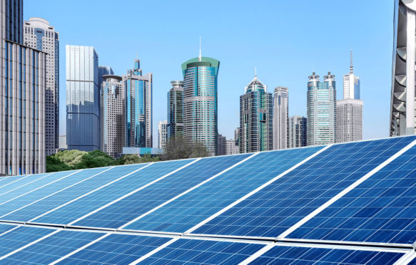 Solar panels in front of Shanghai skyline. Credit: Yong nian Gui / Alamy Stock Photo. HT79MD