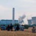 A field of people watch from a distance as the iconic cooling towers of Didcot A coal power station are demolished