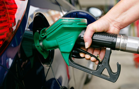 Woman Filling a Car with Unleaded Petrol, UK.