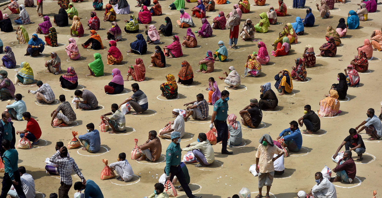 Bangladeshi homeless people wait in a queue for aid during the nationwide coronavirus lockdown. Dhaka, Bangladesh, 4 April 2020. Credit: SK Hasan Ali / Alamy Stock Photo