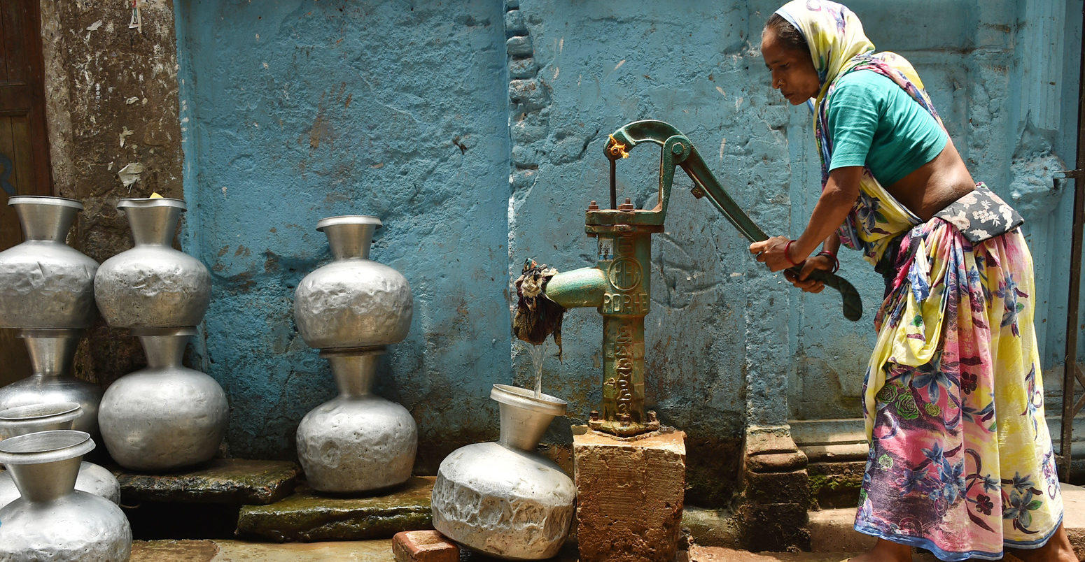 A woman collects water from a well during a heatwave in Dhaka, Bangladesh, on 20 May 2019. Credit: Xinhua / Alamy Stock Photo.